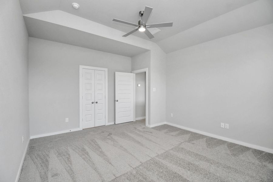 Escape and relax in the exquisite primary suite, a haven to unwind after a long day. The spacious room, boasts plush carpeting, soothing paint tones, high ceilings, and expansive windows adorned with privacy blinds. Sample photo of completed home with similar floor plan. Actual colors and selections may vary.