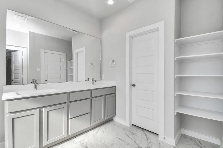 Primary bedroom walk-in closet that epitomizes luxury and practicality. This generously sized space features built-in shelving, offering abundant room for impeccable organization. High ceilings and recessed lighting create a bright and welcoming ambiance. Sample photo of completed home with similar floor plan. Actual colors and selections may vary. Primary bedroom walk-in closet that epitomizes luxury and practicality. This generously sized space features built-in shelving, offering abundant room for impeccable organization. High ceilings and recessed lighting create a bright and welcoming ambiance. Sample photo of completed home with similar floor plan. Actual colors and selections may vary.