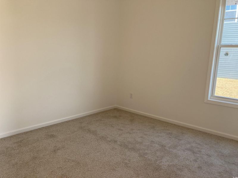Spare room with light carpet and baseboards
