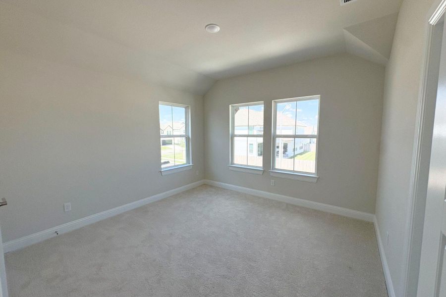 Carpeted room with vaulted ceilings and recessed lighting
