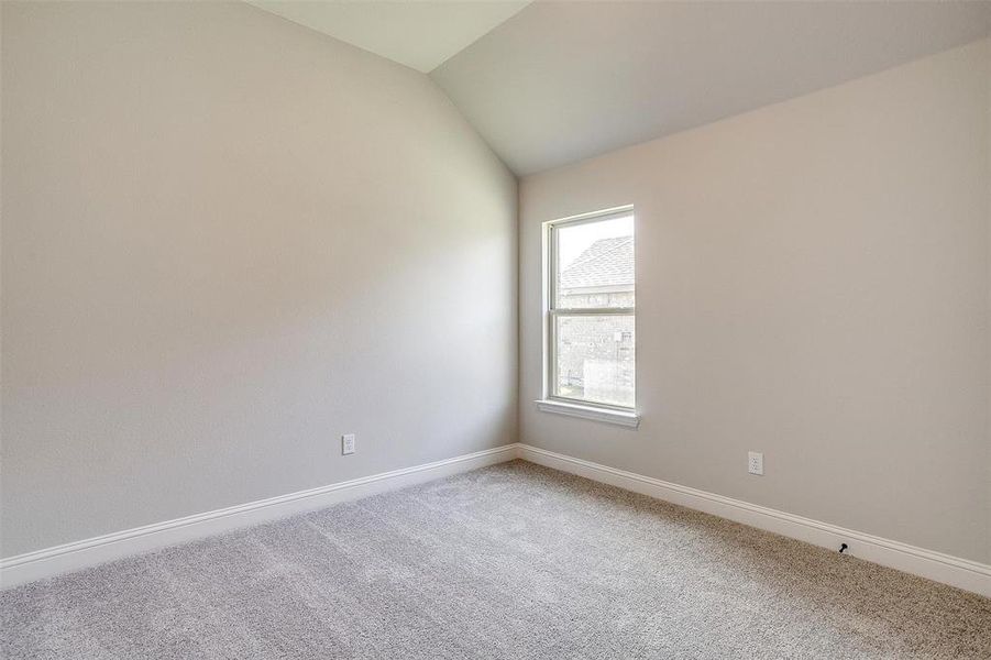 Carpeted spare room with lofted ceiling