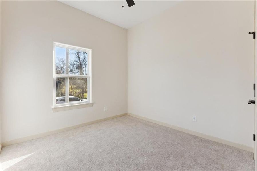 Spare room with ceiling fan and light colored carpet