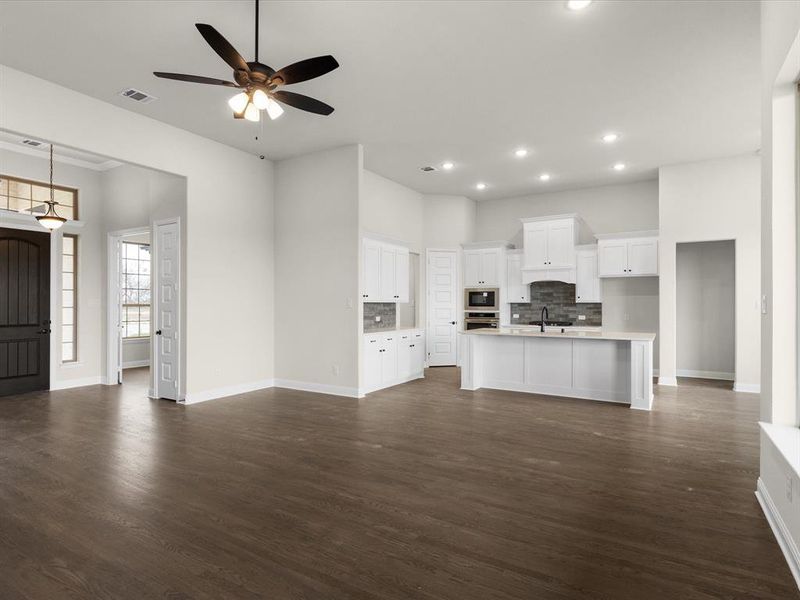 Unfurnished living room with ceiling fan and dark wood finished floors