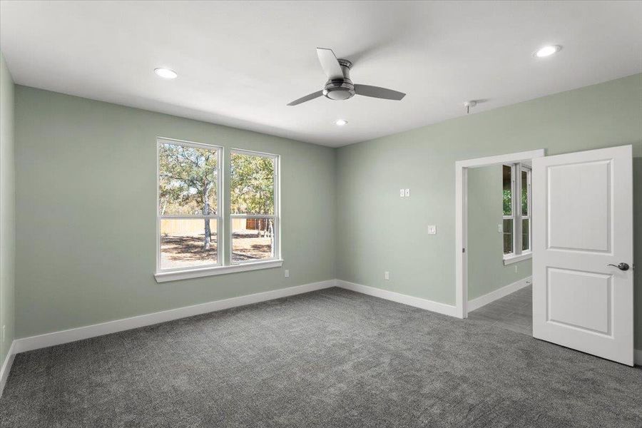 Primary bedroom with carpet flooring, plenty of natural light, recessed lighting, and ceiling fan