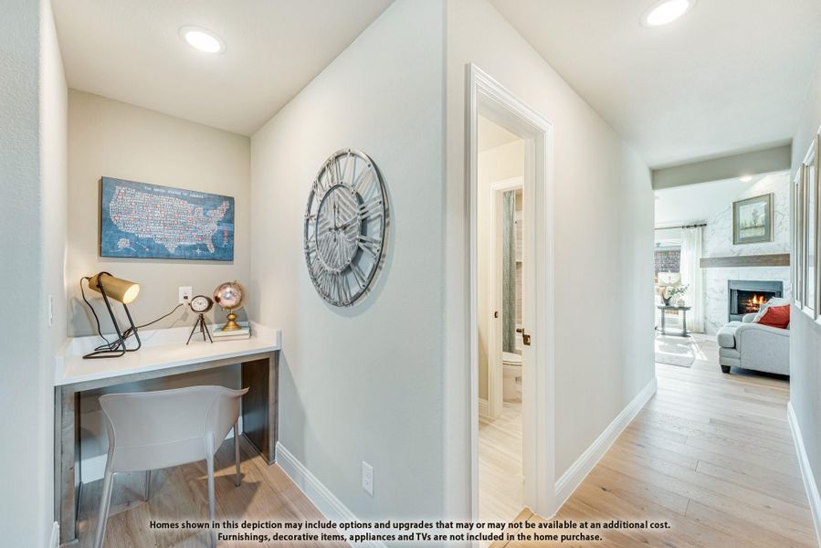 Hallway with built-in desk nook, hardwood floors, and view into living room with fireplace Hallway with built-in desk nook, hardwood floors, and view into living room with fireplace