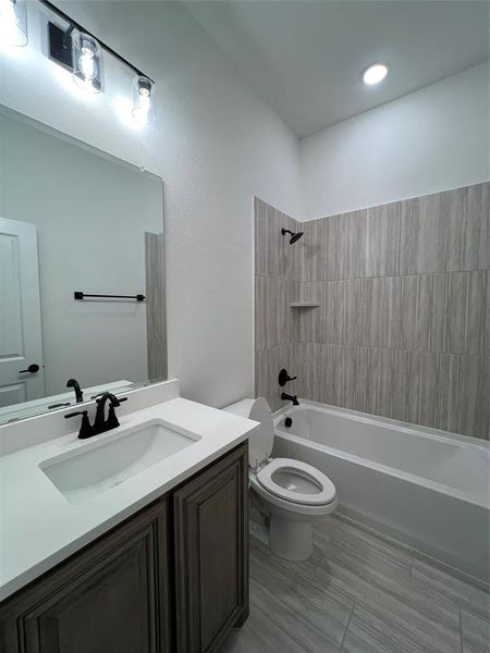 Guest bathroom featuring vanity, sink, ceramic flooring, and bathtub/shower combination Guest bathroom featuring vanity, sink, ceramic flooring, and bathtub/shower combination