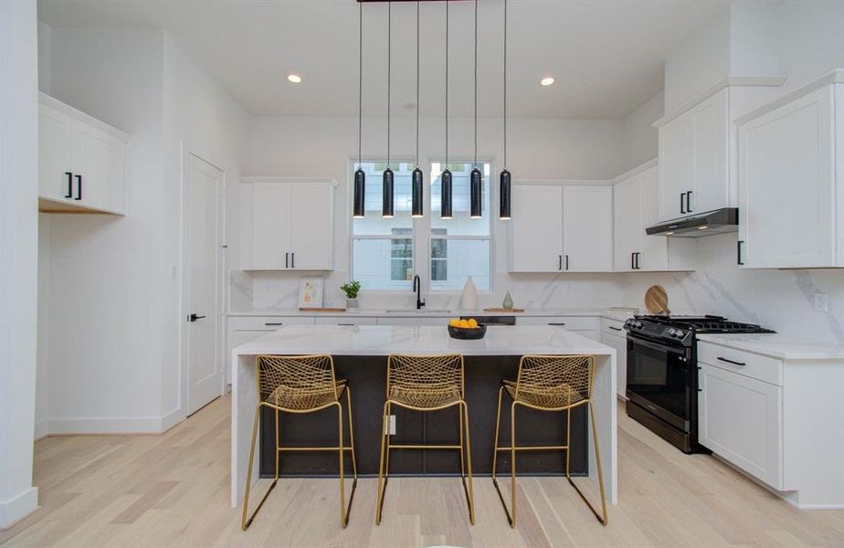 Your future kitchen features minimal architectural lines. A waterfall island, extended quartz backsplash, and a contrasting island