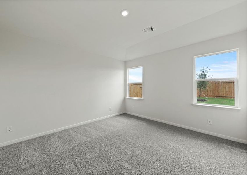 The spacious master bedroom has a large window that lets in natural light and backyard views.