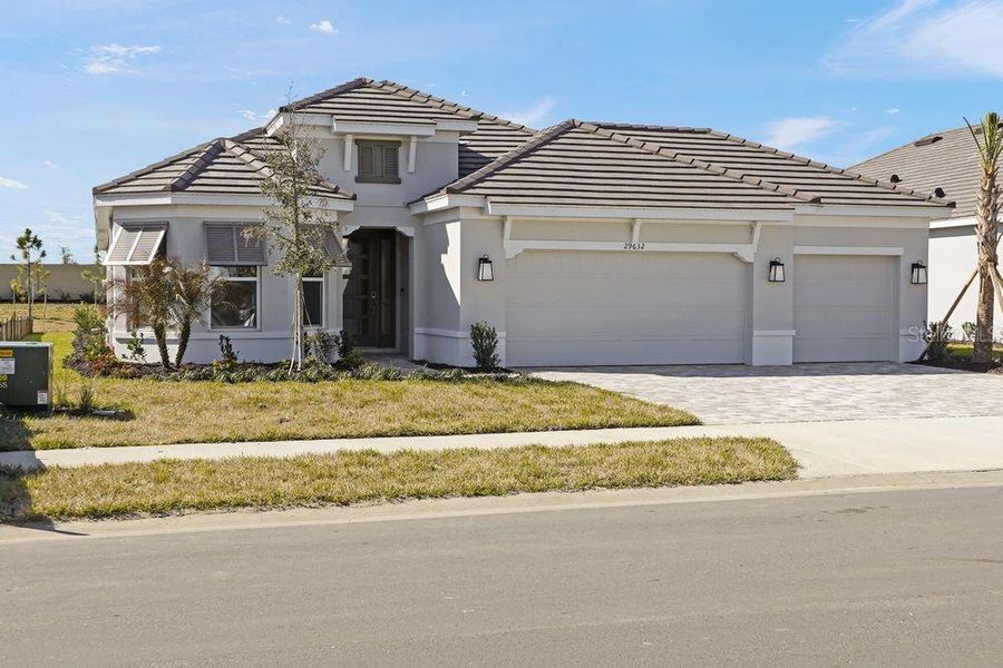 Front exterior of a new home in Esplanade at Wiregrass Ranch, Wesley Chapel, FL, highlighting curb appeal (Image 1). Front exterior of a new home in Esplanade at Wiregrass Ranch, Wesley Chapel, FL, highlighting curb appeal (Image 1).