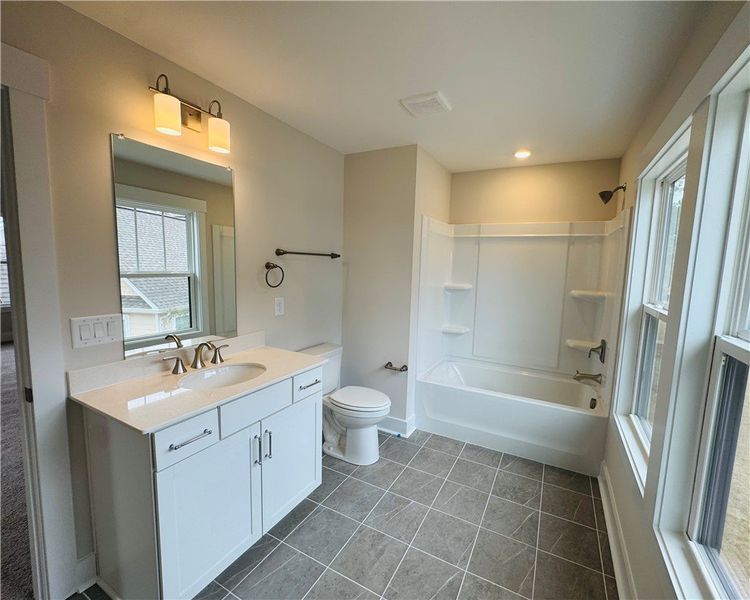 This bathroom features a sleek vanity, bathtub, an