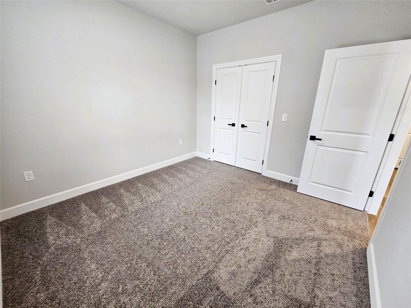 Unfurnished bedroom featuring carpet floors and a closet