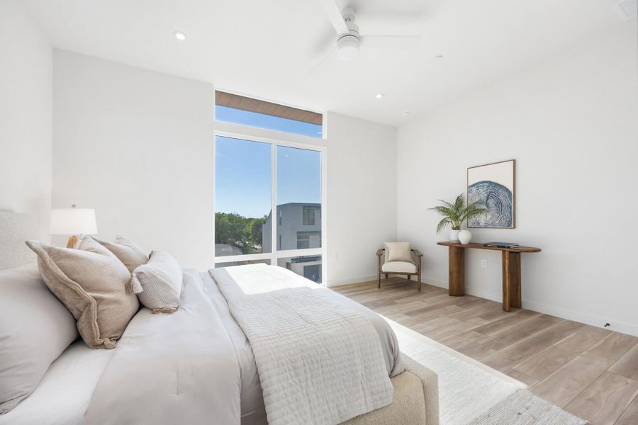 Expansive window wall with transom, recessed lighting, wood-finish flooring, and a ceiling fan