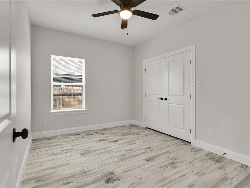 Unfurnished bedroom featuring light wood-type flooring, a closet, and ceiling fan