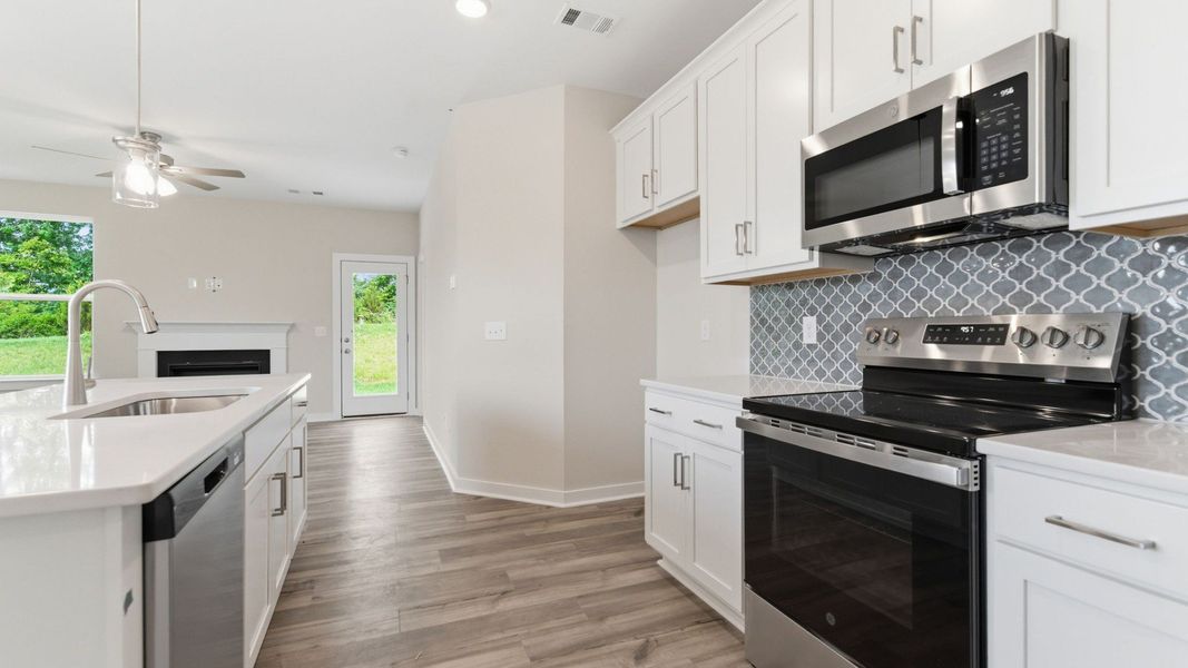 Kitchen with tile backsplash, pendant lighting, and quartz countertops