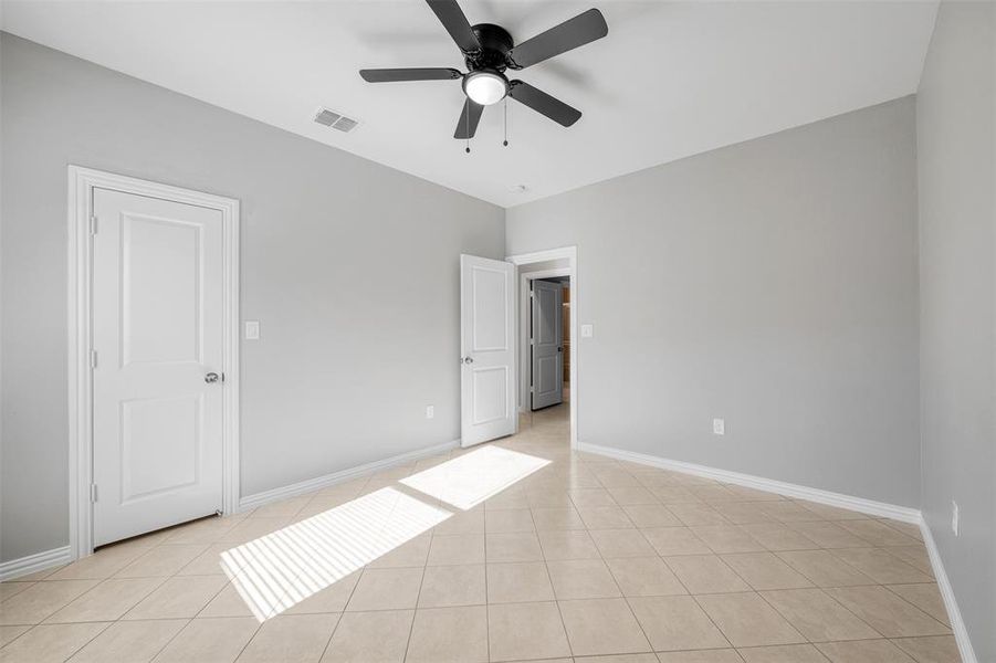 Unfurnished bedroom featuring ceiling fan and light tile patterned flooring