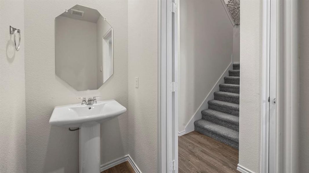 Bathroom featuring dark wood-style floors and a textured wall