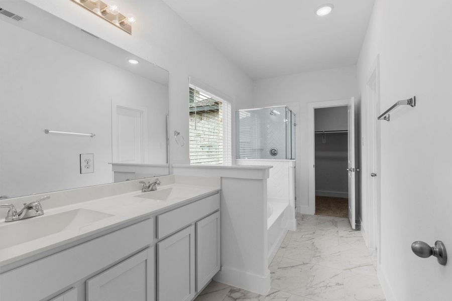 Photo of another bathroom of the primary but looks almost the same!  His and her private sinks, beautiful tile flooring, and wait till you see the massive primary suite walk-in closet!  **Image Representative of Plan Only and May Vary as Built**.