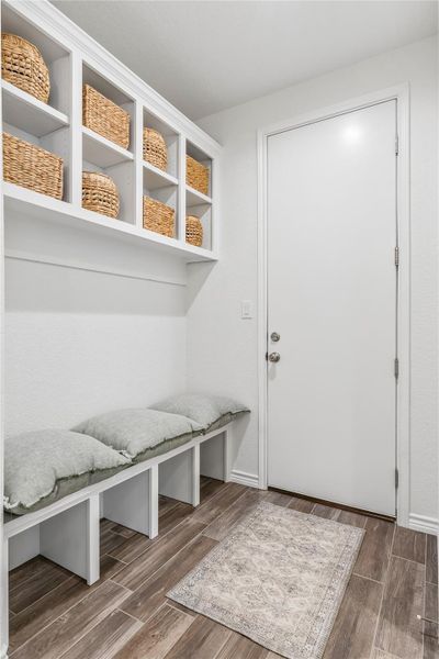 A convenient mudroom entryway provides functional built-in storage and seating.