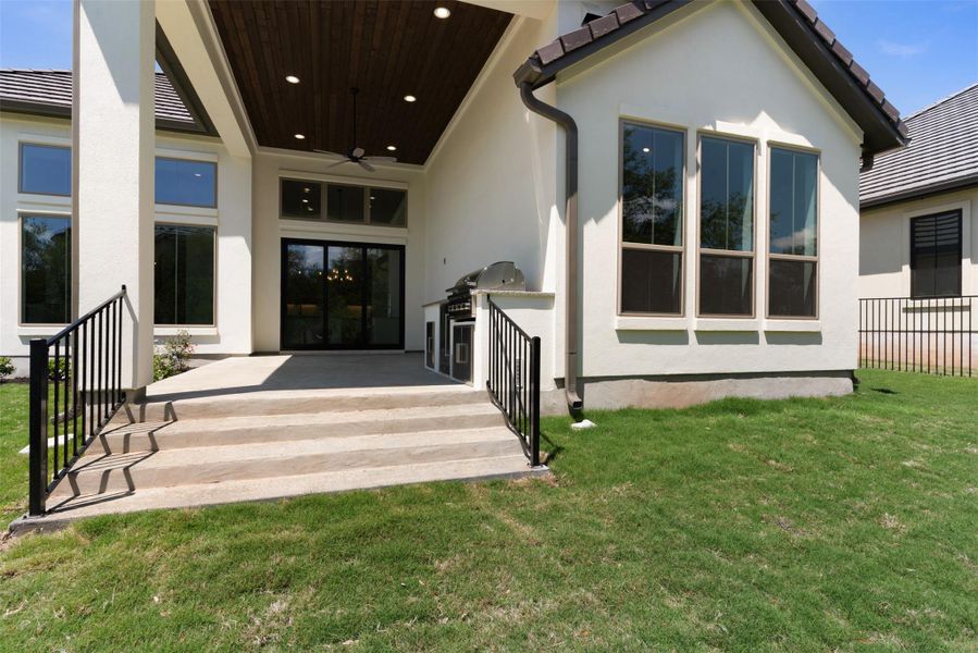 The property features an outdoor patio with a built-in grill, a ceiling fan, and recessed lighting