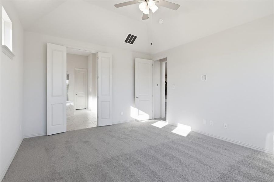 Unfurnished bedroom featuring light carpet, vaulted ceiling, and ceiling fan Unfurnished bedroom featuring light carpet, vaulted ceiling, and ceiling fan