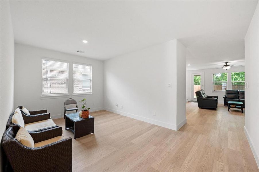 Open-concept living space featuring wood-finish flooring and recessed lighting Open-concept living space featuring wood-finish flooring and recessed lighting