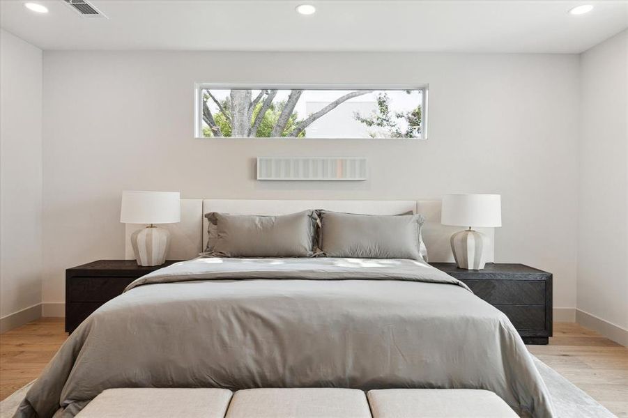 Primary bedroom with windows strategically placed for picturesque view of the surrounding trees.