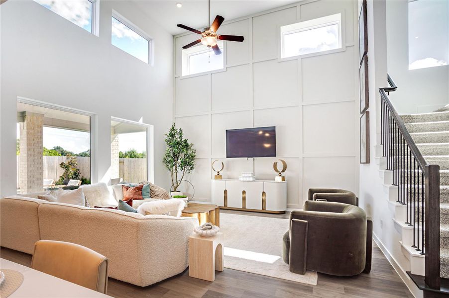 Bright and spacious living room with high ceilings and large windows. The room connects to an outdoor area and a staircase with sleek railings. Bright and spacious living room with high ceilings and large windows. The room connects to an outdoor area and a staircase with sleek railings.