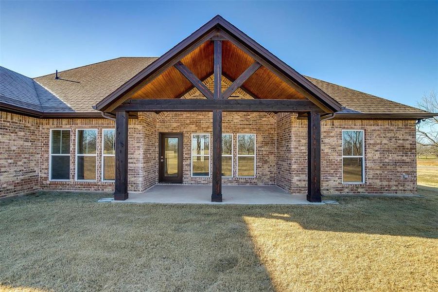 Rear view of house with a patio and a lawn