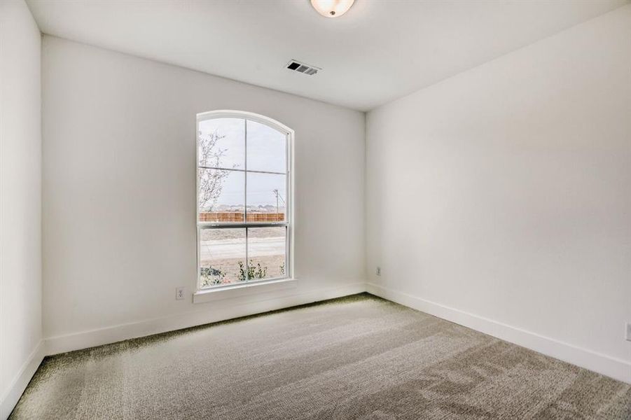 Spare room with carpet and baseboards
