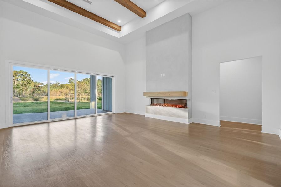 The main living area showcases an impressive open layout with warm flooring, recessed lighting, and refined ceiling details. **Images are from a previously completed project. **