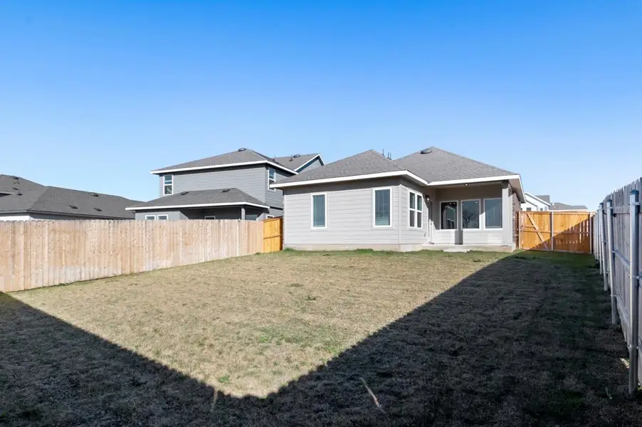 Rear view of house with a fenced backyard, a patio, and a shingled roof