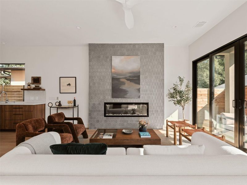 Living area featuring a fireplace, a ceiling fan, and recessed lighting