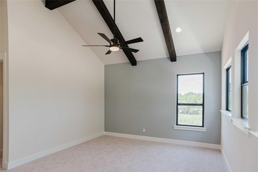 Unfurnished room with beamed ceiling, light carpet, a ceiling fan, and high vaulted ceiling