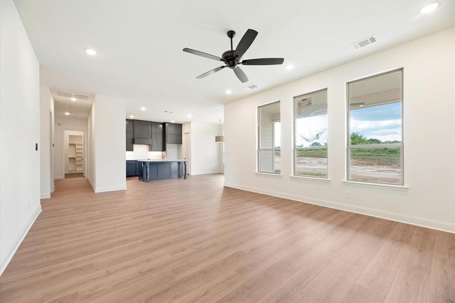 Unfurnished living room featuring light wood-type flooring and ceiling fan