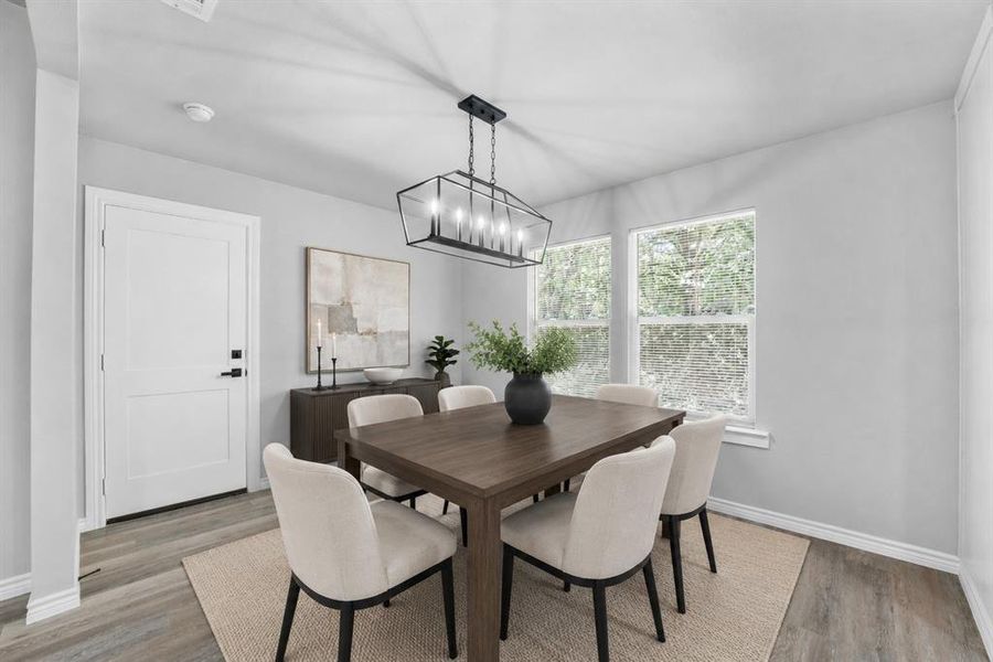 Dining area with wood-finish flooring, light grey walls, and white baseboards Dining area with wood-finish flooring, light grey walls, and white baseboards