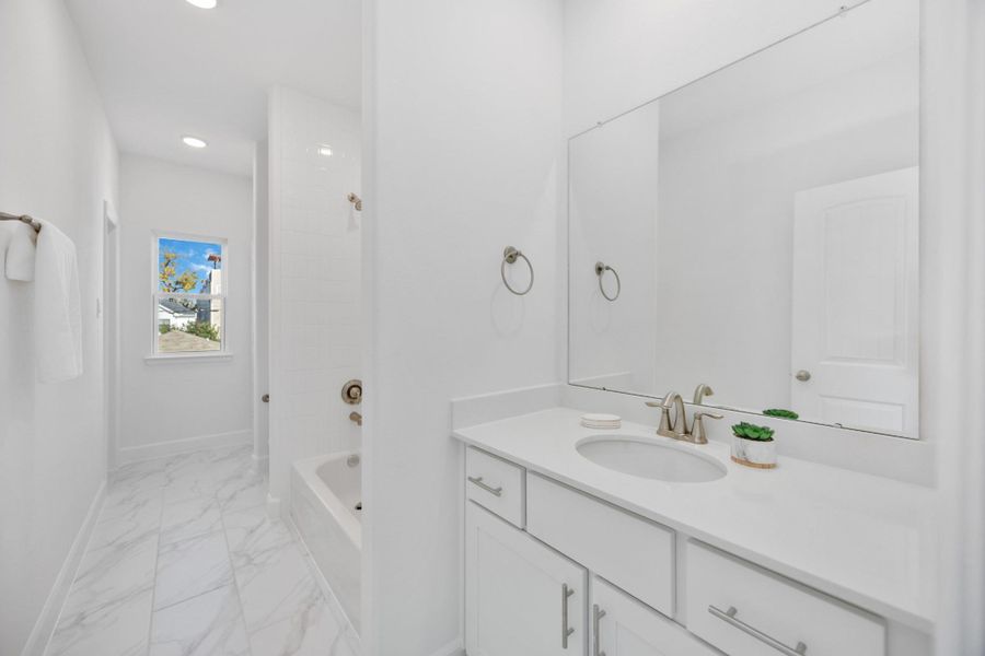 Sleek, Fresh & FunctionalThe shared secondary bath connects both bedrooms with style—bright finishes, abundant counter space, and a tub perfect for wind-down routines.