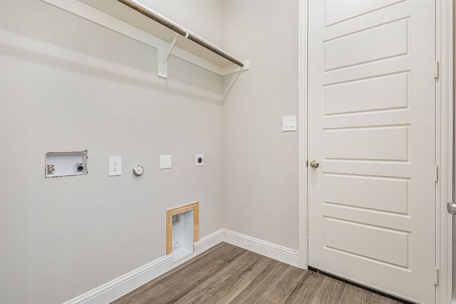 Laundry area featuring gas dryer hookup, hookup for an electric dryer, wood finished floors, and hookup for a washing machine Laundry area featuring gas dryer hookup, hookup for an electric dryer, wood finished floors, and hookup for a washing machine
