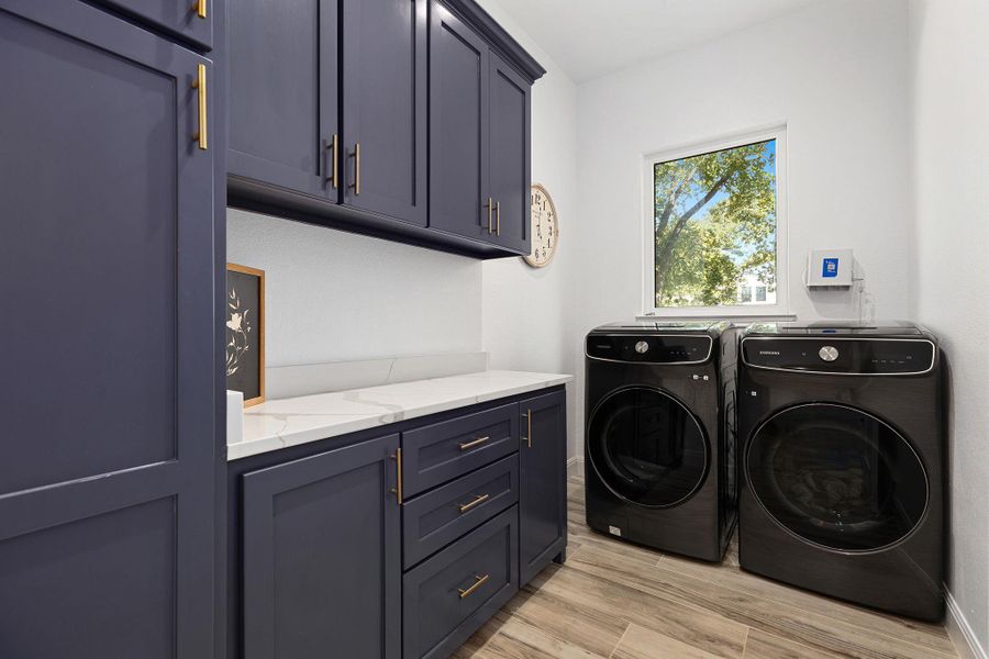 Laundry area with light wood-style flooring, cabinet space, and washer and dryer Laundry area with light wood-style flooring, cabinet space, and washer and dryer