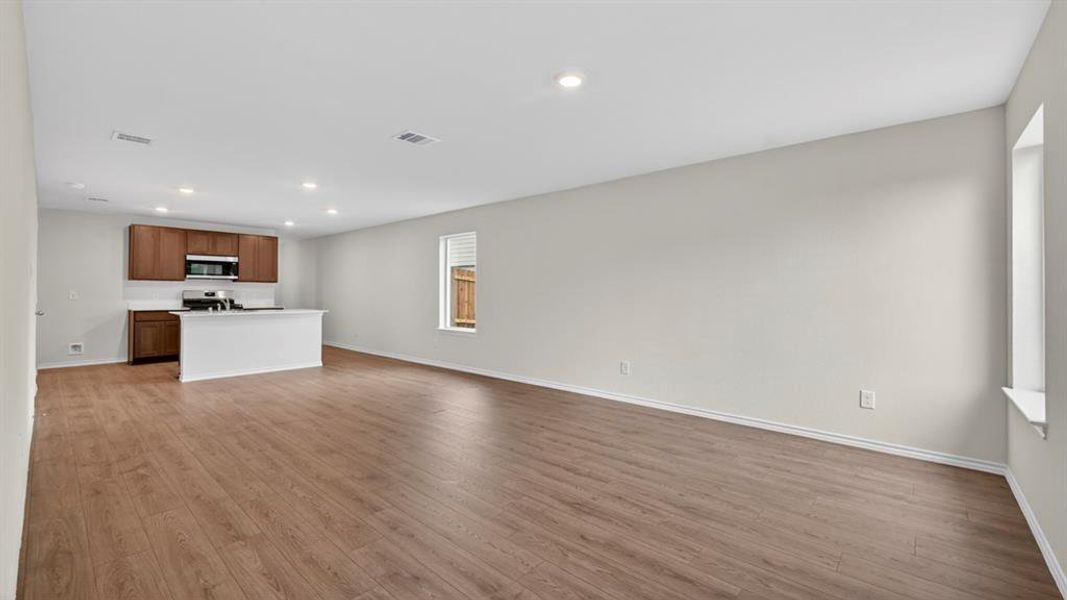 Expansive open-concept room featuring wood-finish flooring, recessed lighting, and neutral wall tones