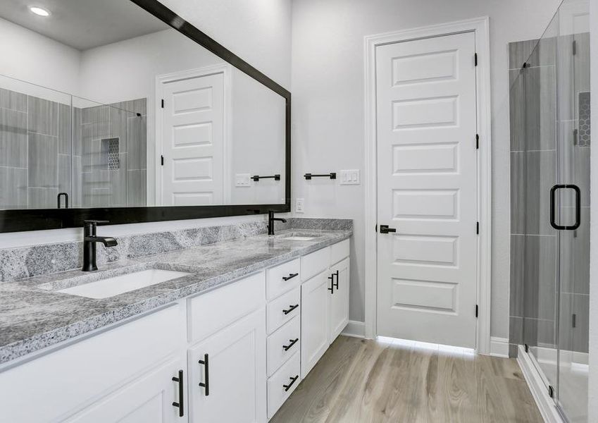 A dual-sink vanity and white cabinetry give the master bath flair.