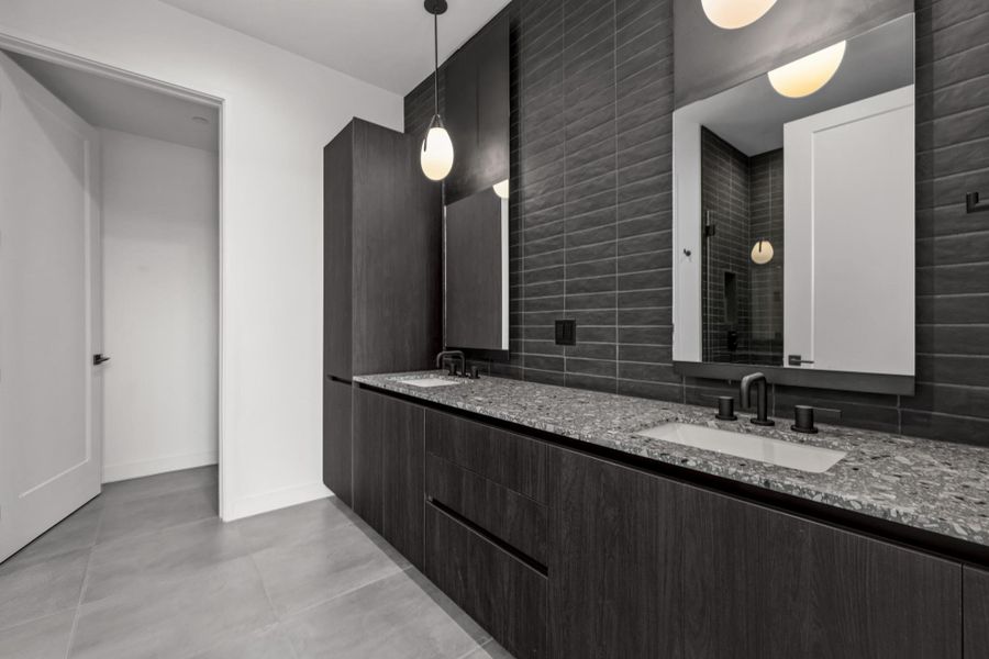 Primary Bath with spacious double vanity, floor to ceiling tile, private water closet, and a walk in shower