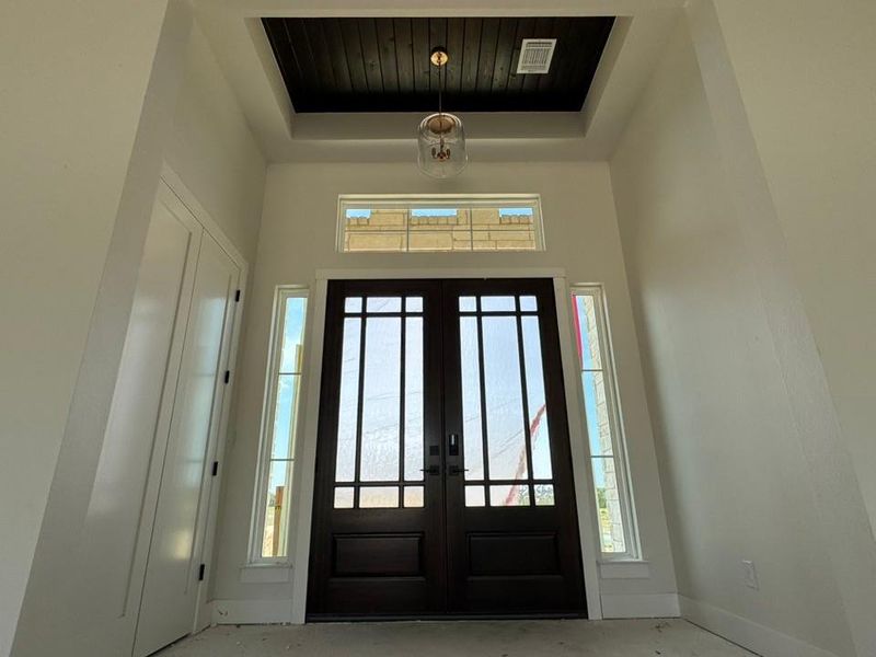 Entryway featuring french doors and a tray ceiling