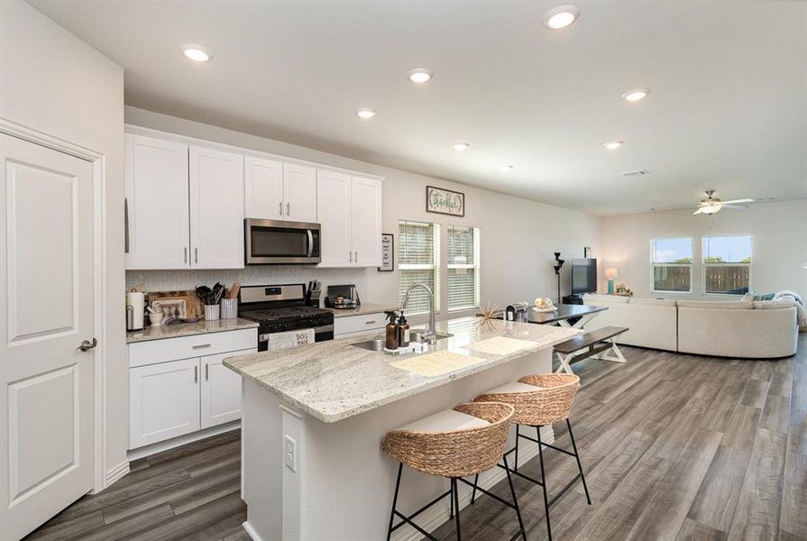 Kitchen with an island with sink, stainless steel appliances, sink, and a healthy amount of sunlight