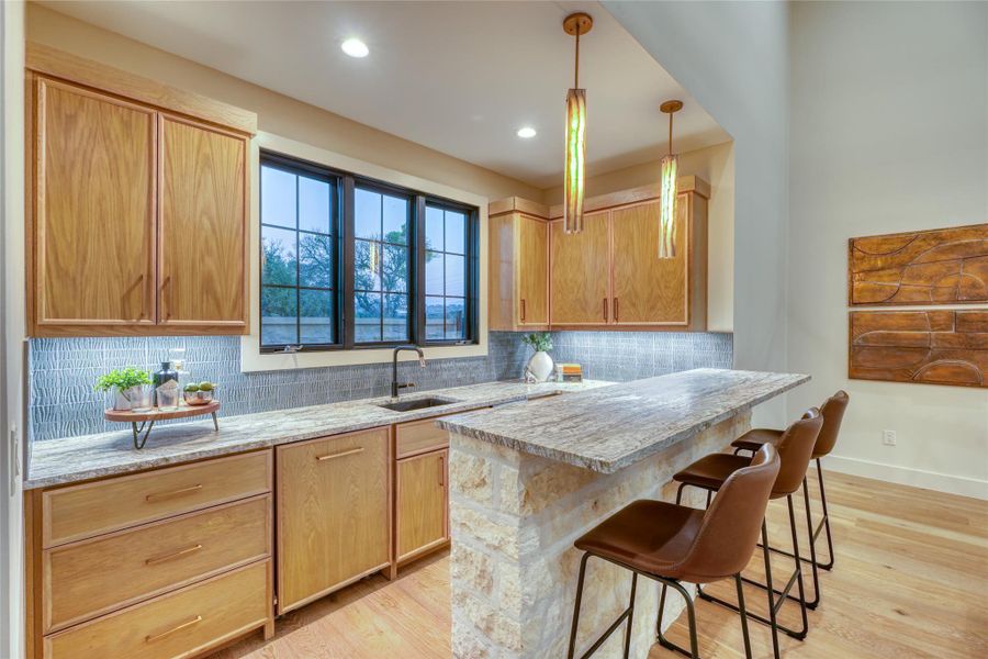 Wet bar with counter seating & high-end Fisher & Paykel appliances.