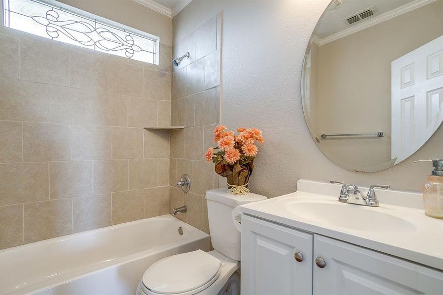 Full bath with vanity, ornamental molding, a textured wall, and bathing tub / shower combination