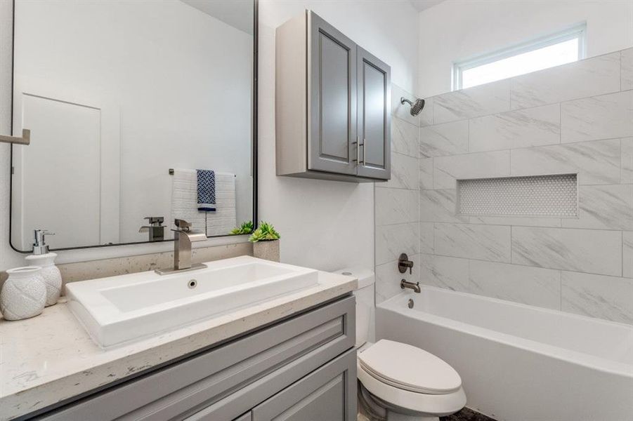 Full bathroom featuring vanity, toilet, and tiled shower / bath