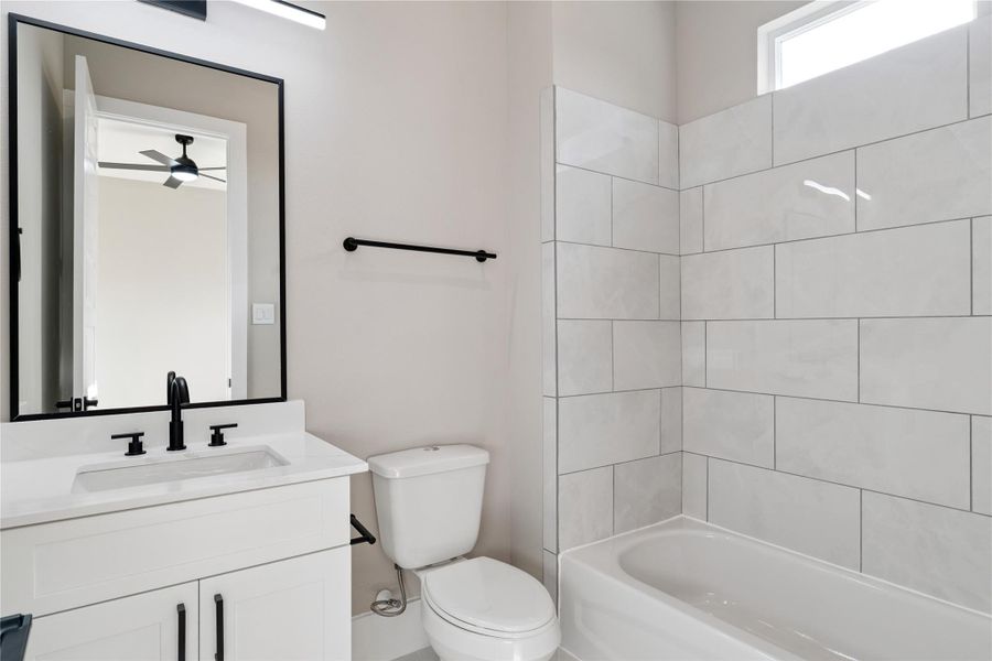 Tile and texture harmonize here, bringing light and balance to the secondary suite’s private space.