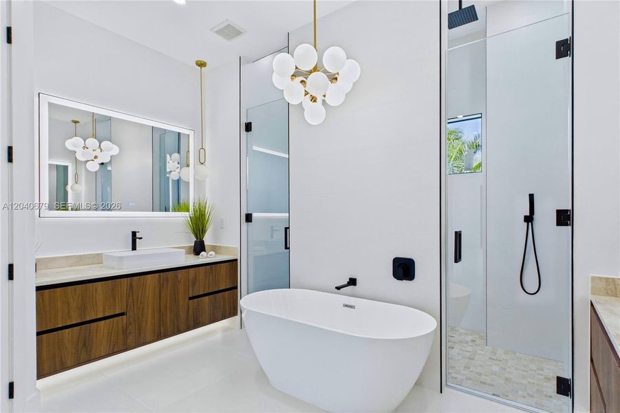 Spa-inspired primary bath showcases a freestanding soaking tub, floating dual vanities, designer lighting, and elegant modern finishes throughou