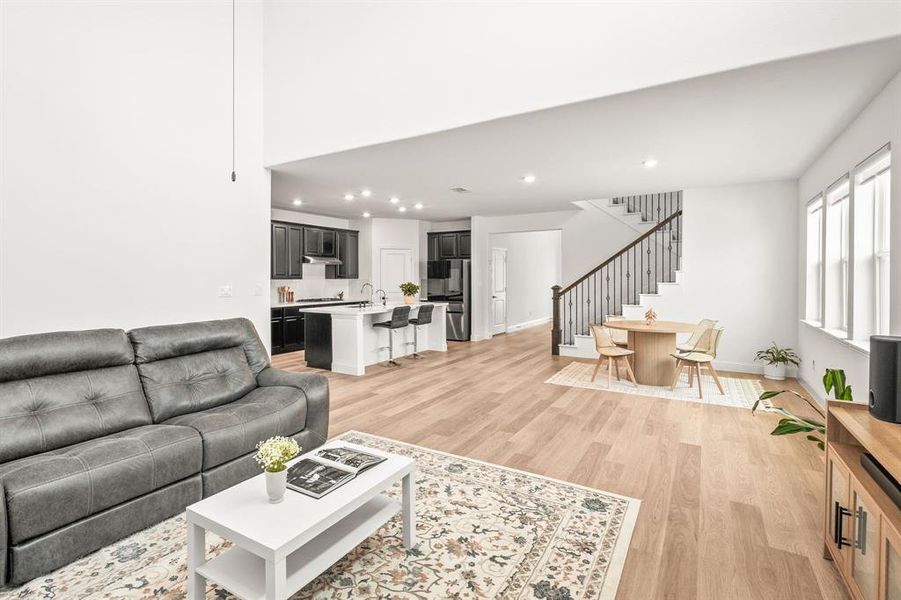 Living room with light wood finished floors and recessed lighting