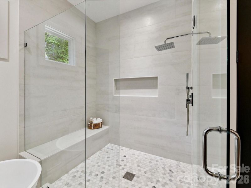 Luxurious primary bathroom featuring a double vanity, freestanding soaking tub, and a spacious glass-enclosed shower with elegant finishes.